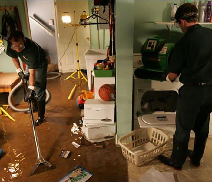 Flooded basement playroom and laundry room. Water covers the floor and belongs in the area.