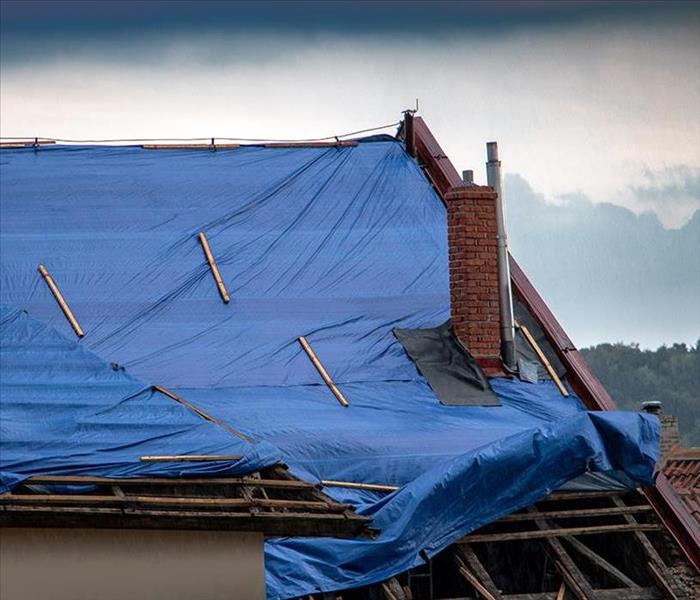 A roof is covered in tarp after a fire.