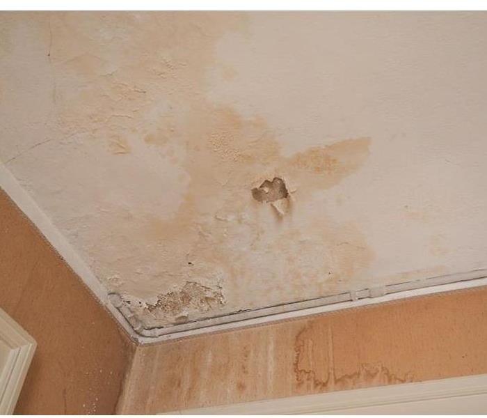 Water Damage In A Structure Shows Water Stains and Peeling Paint on a Ceiling.